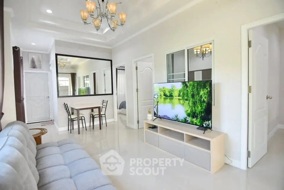 Spacious modern living room with elegant decor and large TV, perfect for relaxation.