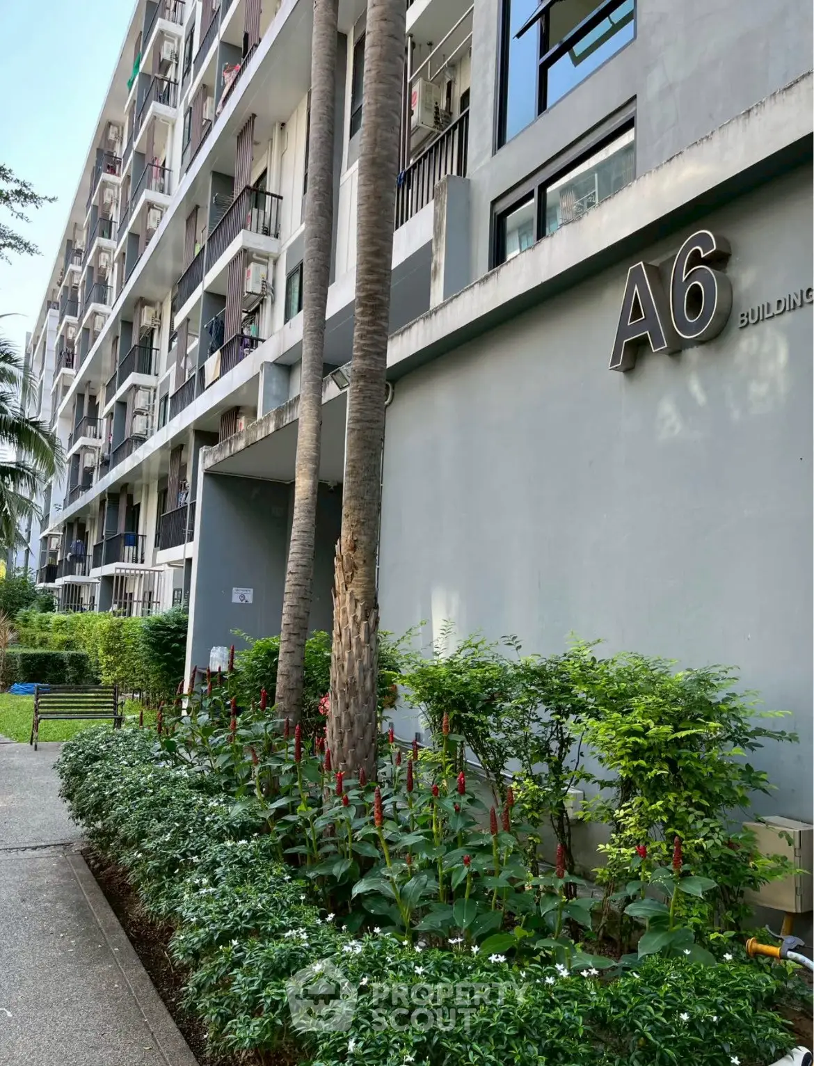 Modern residential building exterior with lush garden and pathway