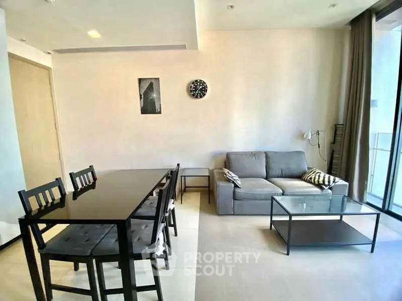 Modern living room with sleek furniture and large windows for natural light.
