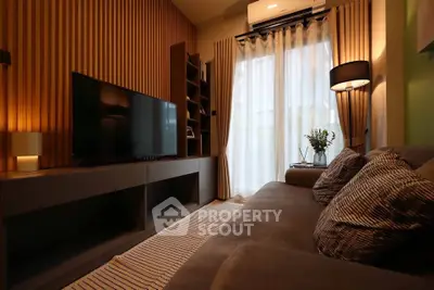 Stylish modern living room with cozy sofa and large TV, perfect for relaxation.