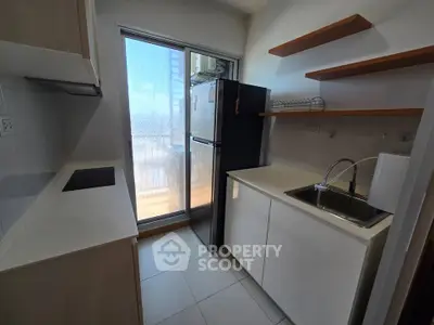 Modern kitchen with sleek design, featuring open shelves and a large window for natural light.
