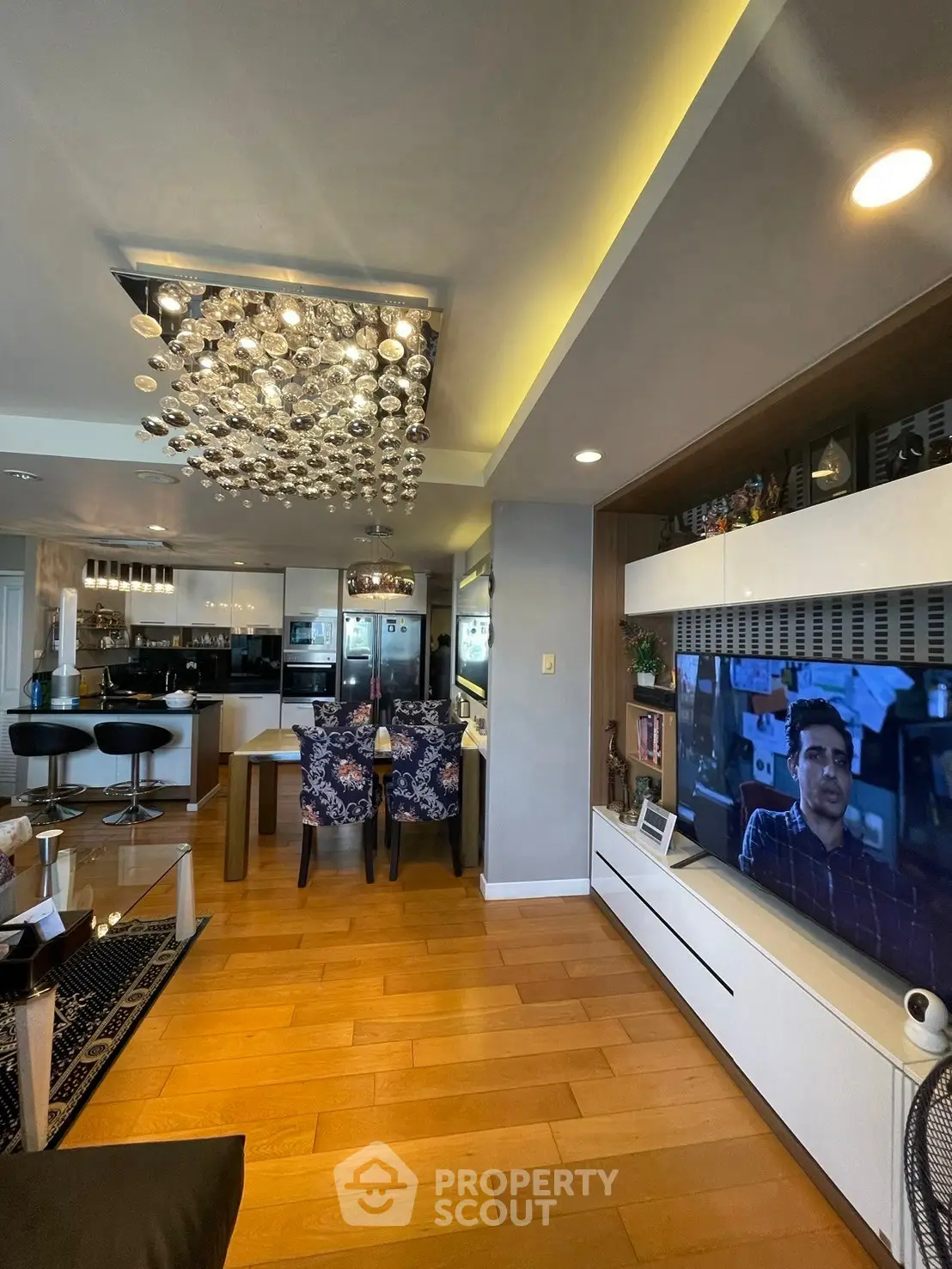 Luxurious open-plan living room with modern kitchen and stylish chandelier