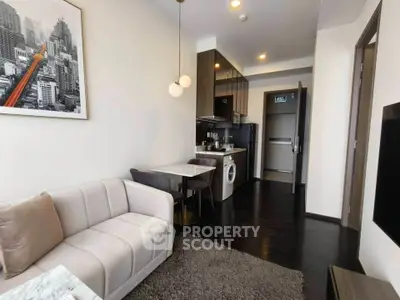 Modern apartment living room with cozy sofa, dining area, and compact kitchen featuring washing machine.