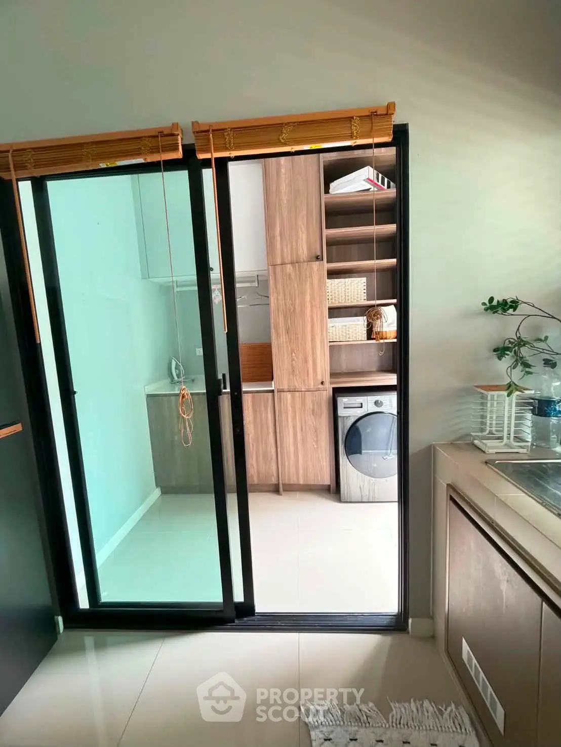 Modern kitchen with sliding glass door leading to laundry area with washing machine.
