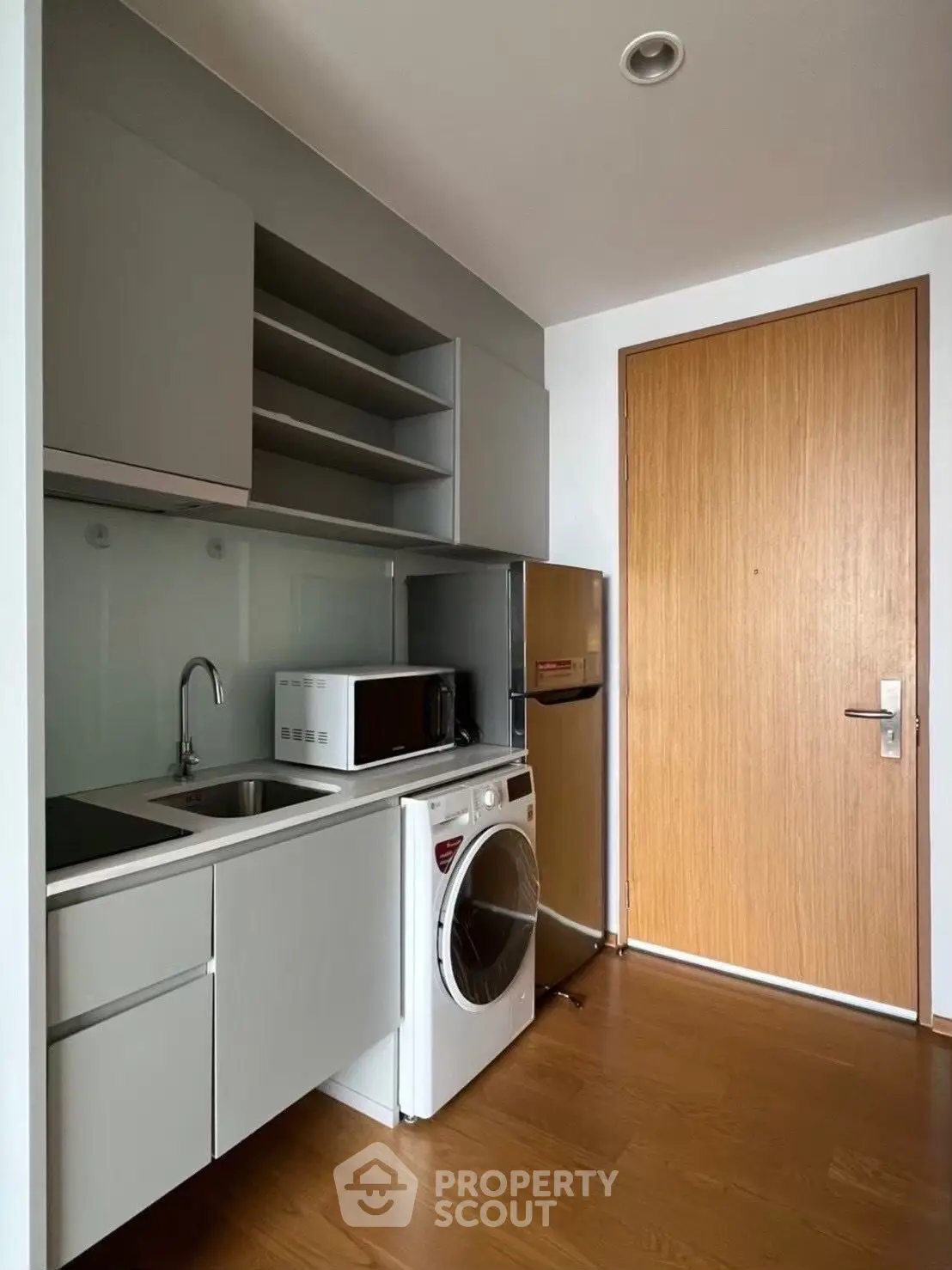 Modern compact kitchen with sleek cabinetry and integrated appliances