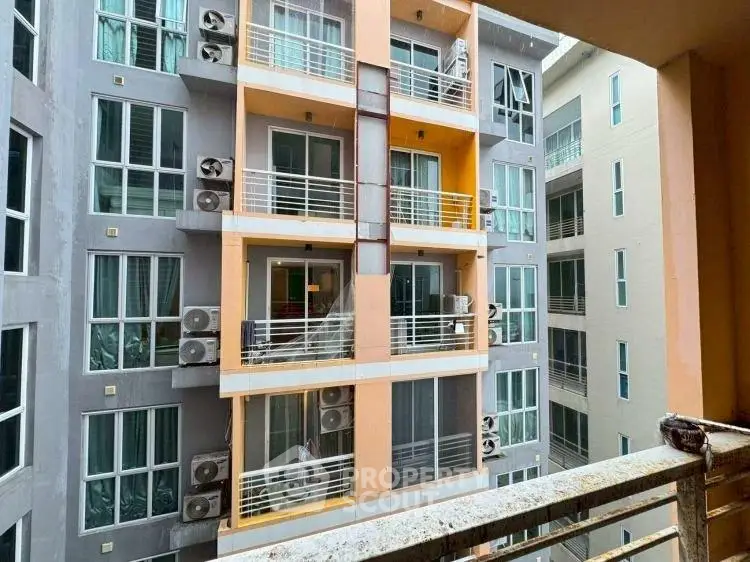 Modern apartment building exterior with multiple balconies and large windows.