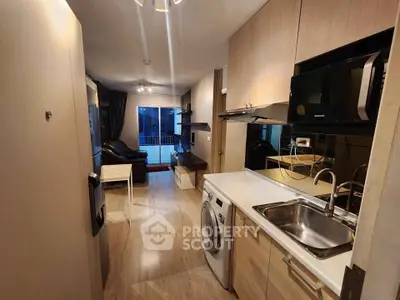 Modern apartment interior with open kitchen and living area, featuring sleek appliances and cozy decor.