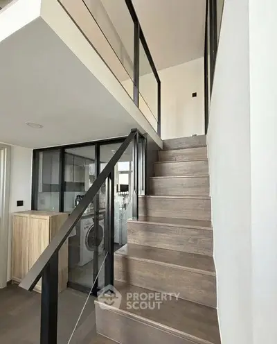 Modern duplex interior with sleek staircase and glass railings