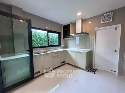 Modern kitchen with sleek cabinetry and large window for natural light