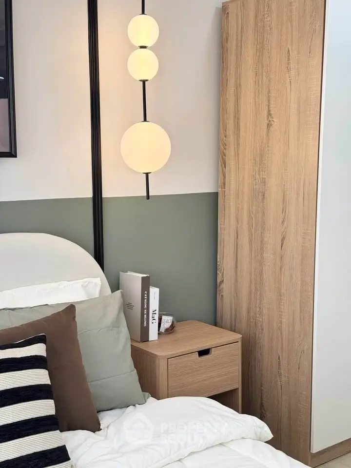 Modern bedroom with stylish lighting and cozy decor, featuring a wooden nightstand and elegant bedding.