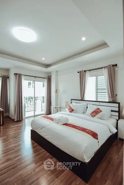 Luxurious bedroom with elegant decor and large windows offering natural light.