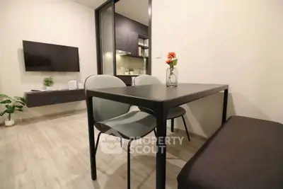 Modern dining area with sleek table and chairs, open layout to living room, stylish interior design.