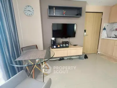 Modern living room with stylish furniture and wall-mounted TV in a cozy apartment.