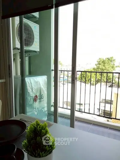 Modern balcony with sliding glass doors and air conditioning unit, offering a serene view.