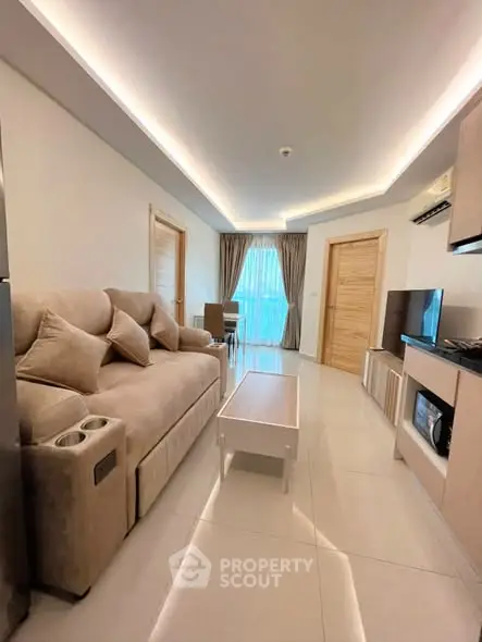 Modern living room with cozy sofa, stylish decor, and natural light from large window.
