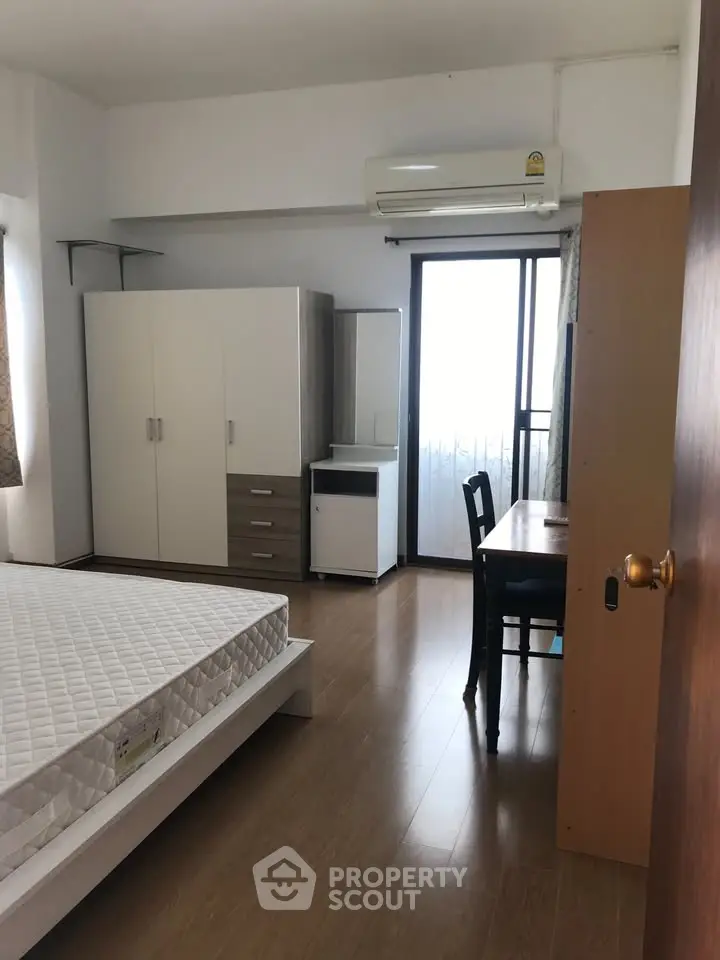 Spacious bedroom with modern furniture and balcony access in a stylish apartment.