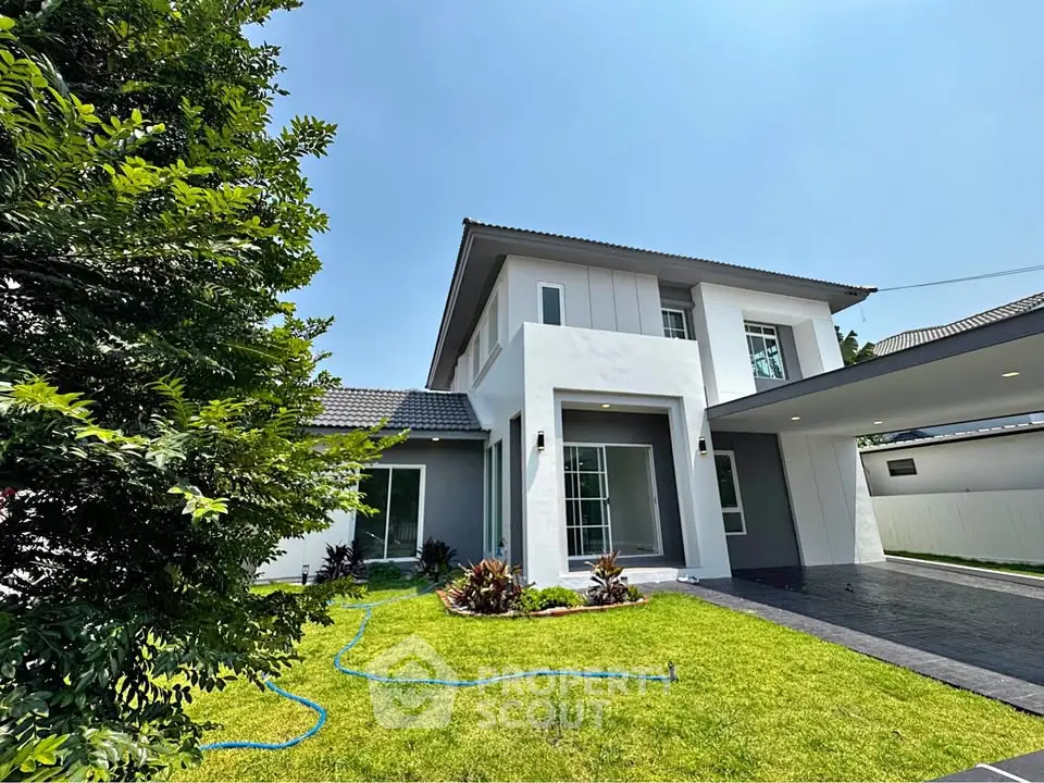 Stunning modern two-story house with lush green lawn and sleek driveway, perfect for family living.