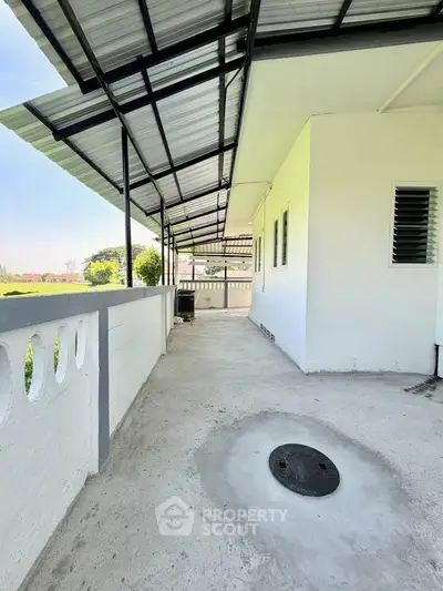 Spacious outdoor balcony with modern roofing and scenic views, perfect for relaxation and entertainment.