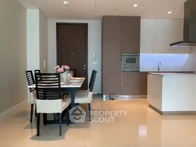 Modern kitchen with dining area and sleek cabinetry in open layout.