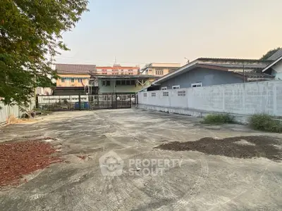 Spacious concrete yard with surrounding buildings, ideal for parking or outdoor activities.