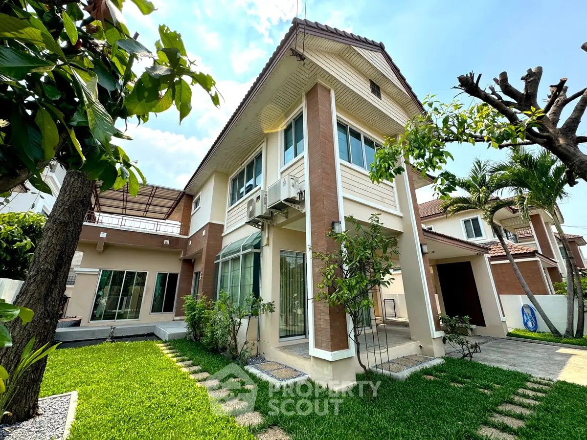 Charming two-story house with lush garden and modern architecture, perfect for family living.
