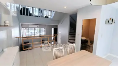 Spacious duplex interior with modern dining area and staircase