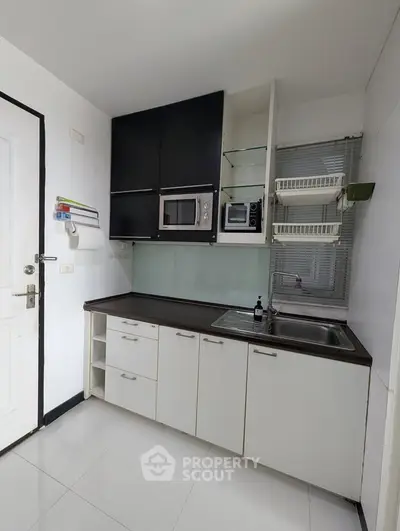Modern kitchen with sleek cabinetry and built-in microwave