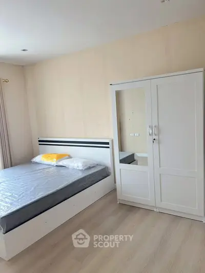 Modern bedroom with sleek white furniture and cozy bed in a bright apartment.