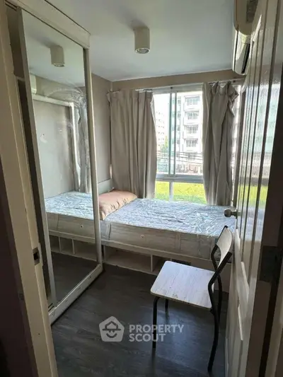 Cozy bedroom with mirrored wardrobe and large window view