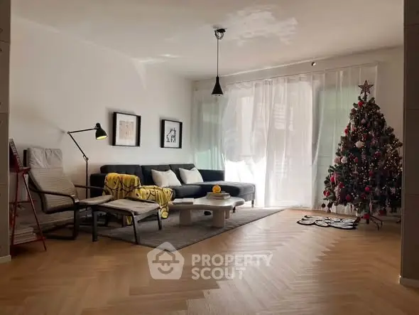 Stylish living room with Christmas tree and modern decor, perfect for holiday gatherings.