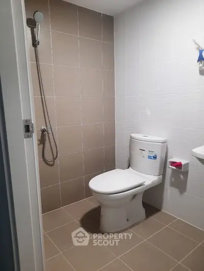Modern bathroom with sleek tiles and shower in real estate property