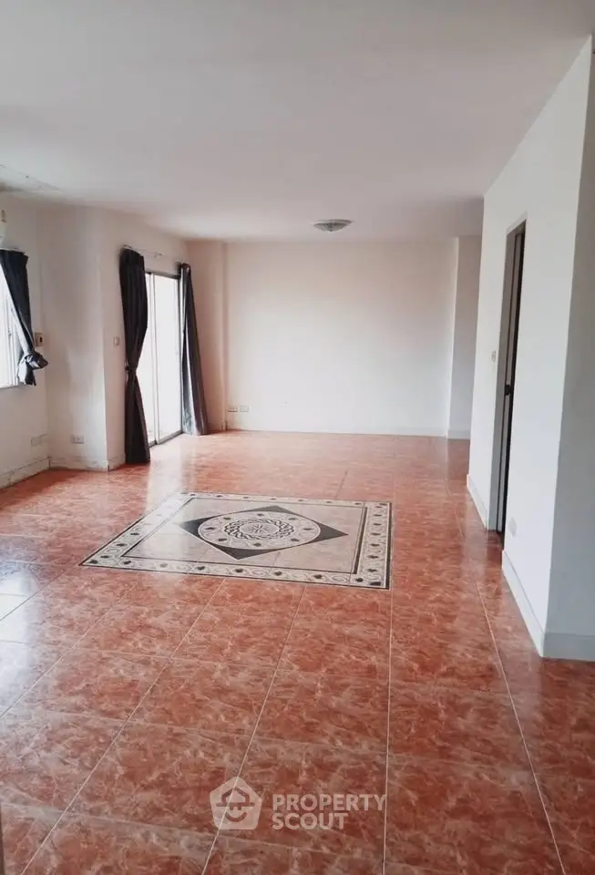 Spacious living room with elegant tiled flooring and natural light