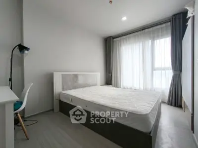 Modern minimalist bedroom with large window and natural light