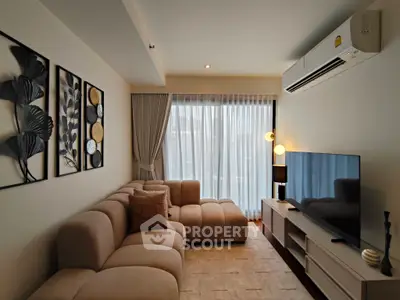 Modern living room with stylish decor, cozy sectional sofa, and large window with sheer curtains.