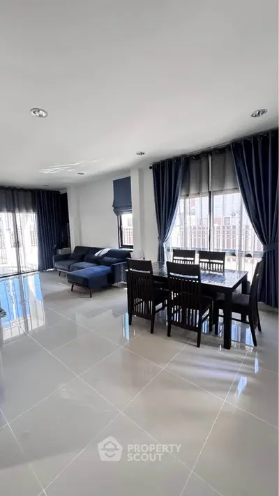 Spacious modern living room with elegant dining area and large windows.