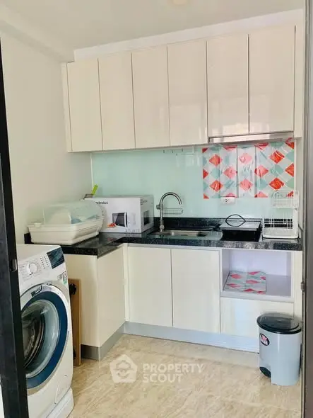 Modern compact kitchen with washing machine and sleek cabinetry