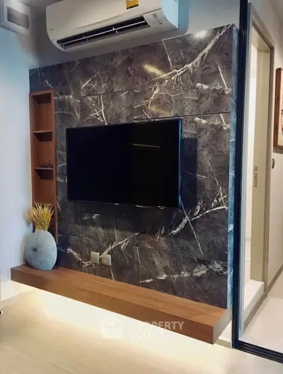 Modern living room with sleek TV setup and stylish marble accent wall.