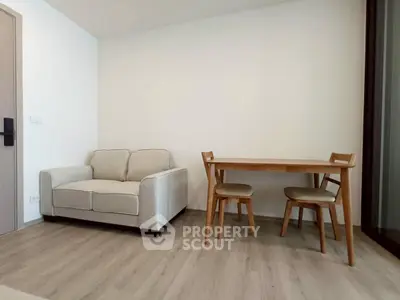 Modern living room with cozy sofa and wooden dining set, perfect for urban living.