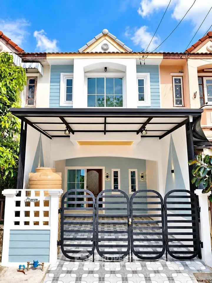 Charming two-story townhouse with modern facade and gated driveway