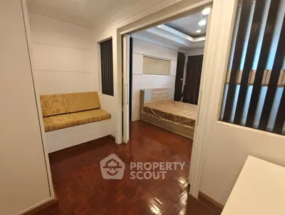 Elegant bedroom with wooden flooring and cozy seating area