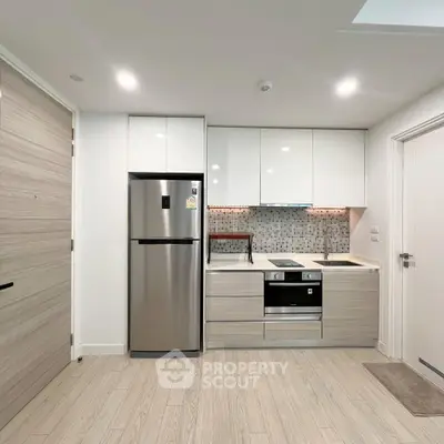 Modern kitchen with sleek appliances and stylish backsplash in a contemporary apartment.