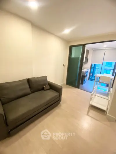 Cozy living room with modern sofa and open kitchen view in stylish apartment