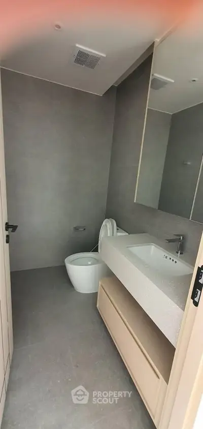 Modern bathroom with sleek design and neutral tones, featuring a spacious vanity and contemporary fixtures.