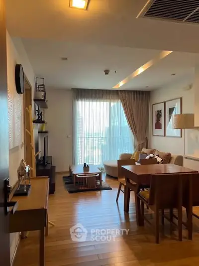 Spacious living room with modern decor and large window offering city views.