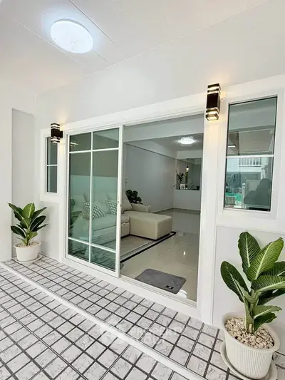 Modern living room with sliding glass doors and stylish potted plants, offering a sleek and inviting atmosphere.