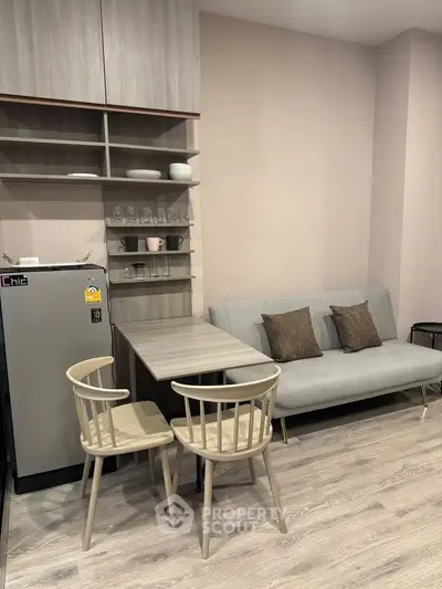 Modern compact living room with stylish furniture and integrated kitchen area, perfect for urban living.
