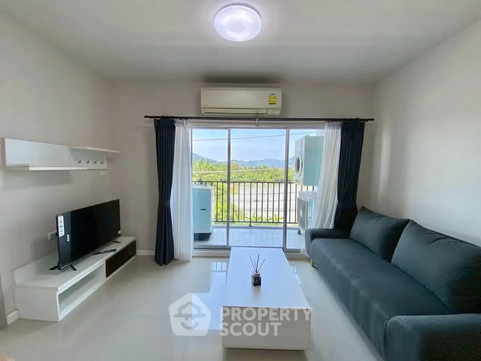 Modern living room with balcony view, sleek furniture, and natural light in a stylish apartment.