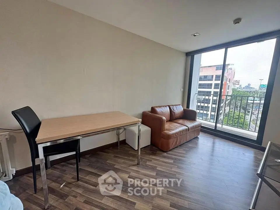 Modern living room with city view, featuring sleek furniture and large windows for natural light.