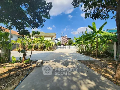 Spacious garden area with lush greenery and clear blue sky, perfect for outdoor activities.