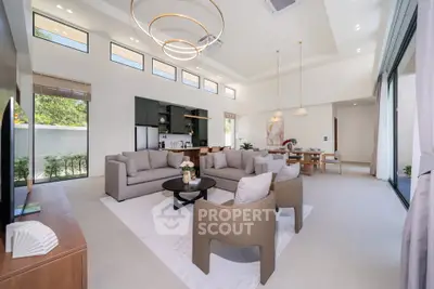Luxurious open-plan living room with modern furniture and large windows offering natural light.